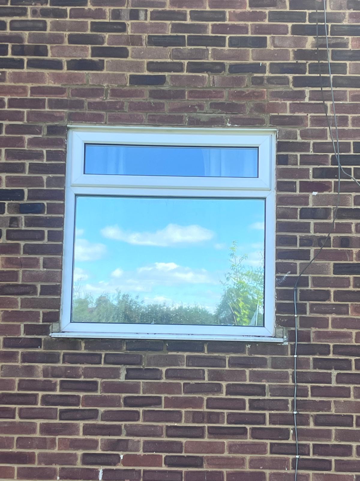 Residential window where the main pane has film fitted and the small top pane does not