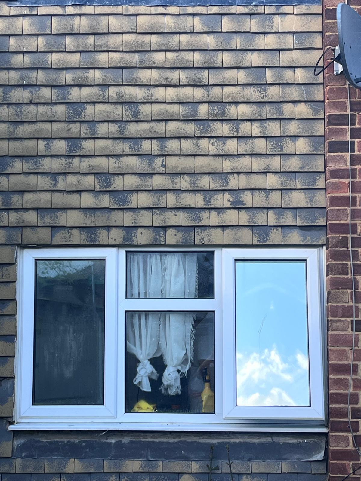 A window with reflective film beside an untreated pane for comparison